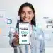 Mujer usando un smartphone para encontrar descuentos en plataformas online en España, sonriendo con satisfacción.