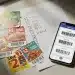 Cupones de descuento físicos y digitales junto a una lista de la compra, representando la planificación para ahorrar en supermercados.