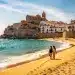 Pareja disfrutando de descuentos ocultos en un viaje a una playa española soleada en 2026, con hoteles y vuelos asequibles.