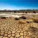 Paisaje árido y suelo agrietado por la sequía en España, reflejando la grave escasez hídrica.